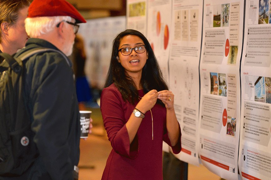 Student explains her final RCP project poster to community resident