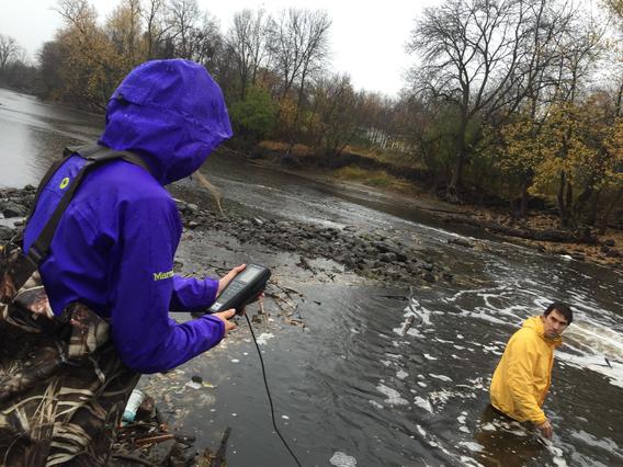 Students collect data in a river for a civil engineering grad course